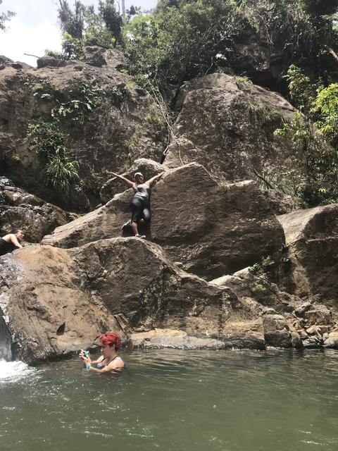 A person posing on large rocks in a natural setting.