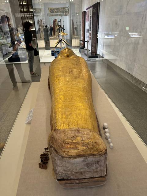 Golden sarcophagus on display in a museum.