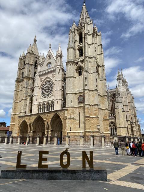 Cathedral facade with large sign and clear blue sky.