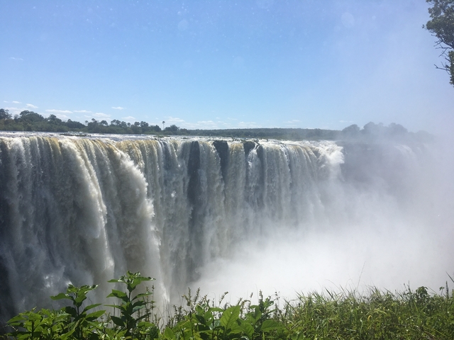 Victoria Falls seen from the top, with mist rising and water flowing.