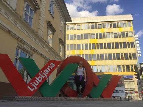Person standing in front of a Ljubljana sign.