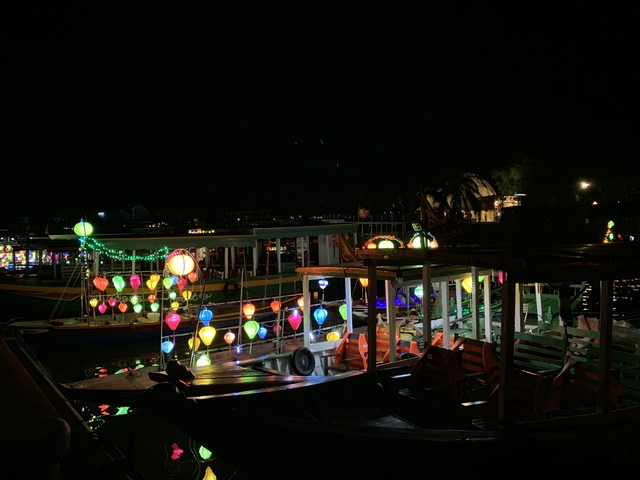 Colorful lanterns and boats on a river at night.