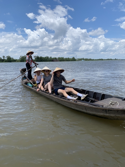 People rowing a traditional boat on a river.