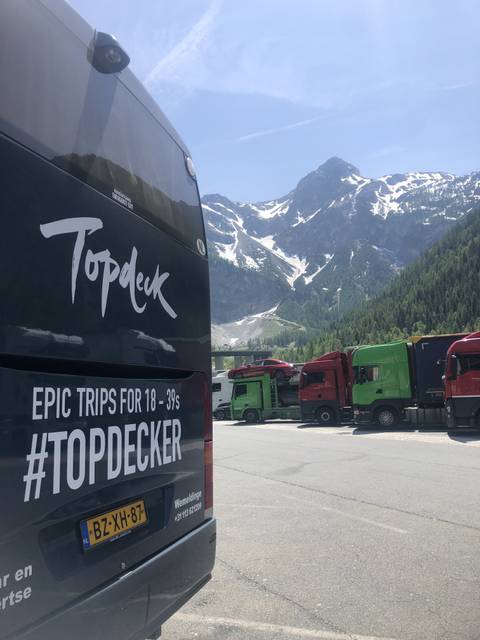 View of a mountainous landscape with vehicles and a tour bus.