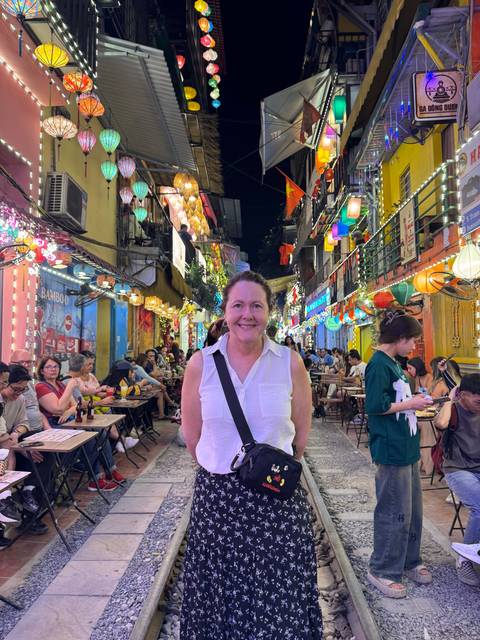 Woman posing on a colorful, busy street at night.