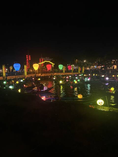 Lanterns on a river at night creating a colorful scene.
