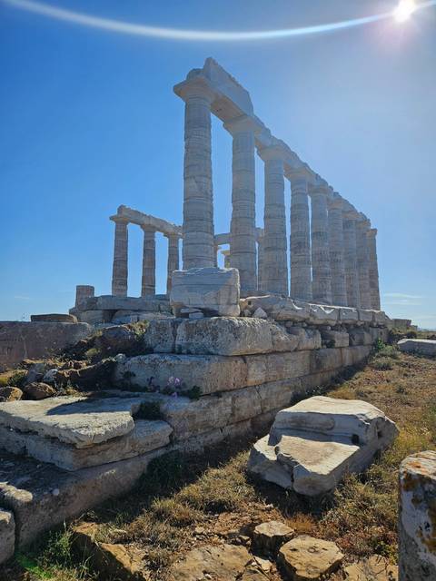 Historical stone columns against a bright blue sky.