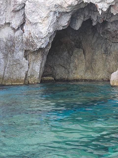 Rocks beside a clear blue sea.