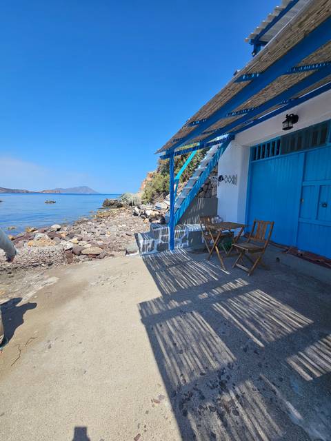 A seaside village scene with chairs and a view of the sea.