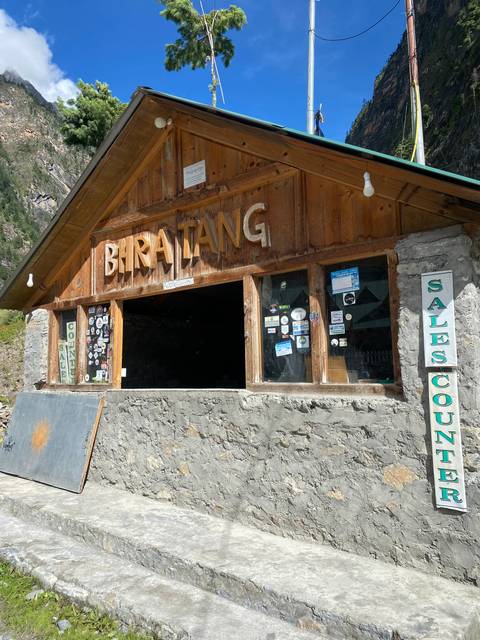 Wooden shelter with stickers and a sign saying 'Biratang'.