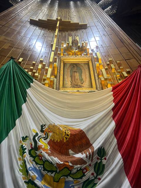 Mexican flag beside a religious painting.