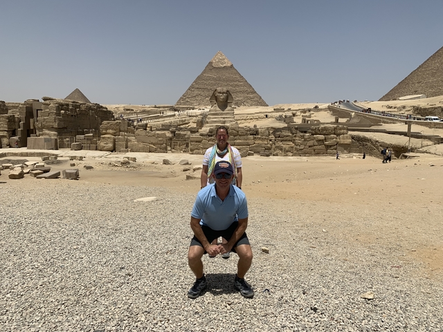 Tourists posing with the pyramids and the Sphinx in Giza.