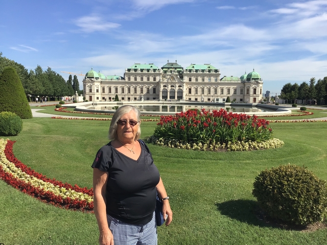 A woman standing in front of the Belvedere Palace gardens.