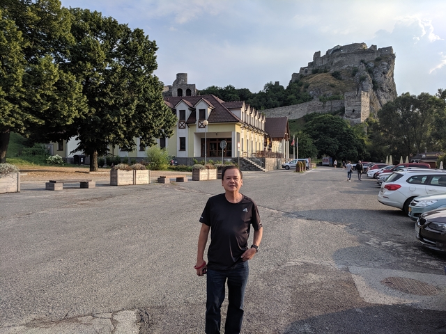 Man standing in front of an old fortress and building.