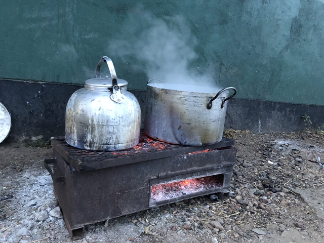 Boiling pots on an outdoor cooking stove.