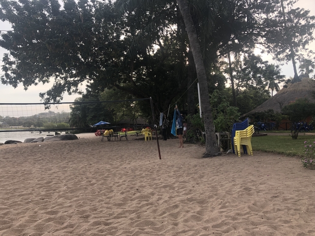 A beachside area with a volleyball net and people.