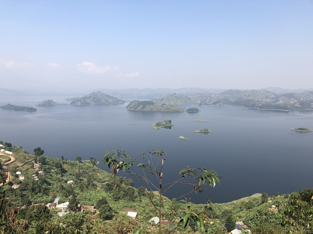 A panoramic view of a lake with islands and distant hills.