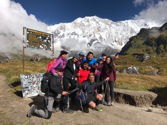 Hikers posing with mountains in the background.