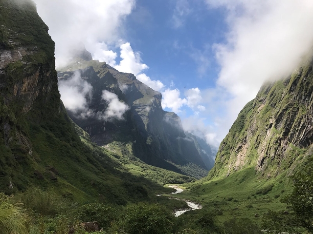 A stunning view of a valley with lush green hills and a river.