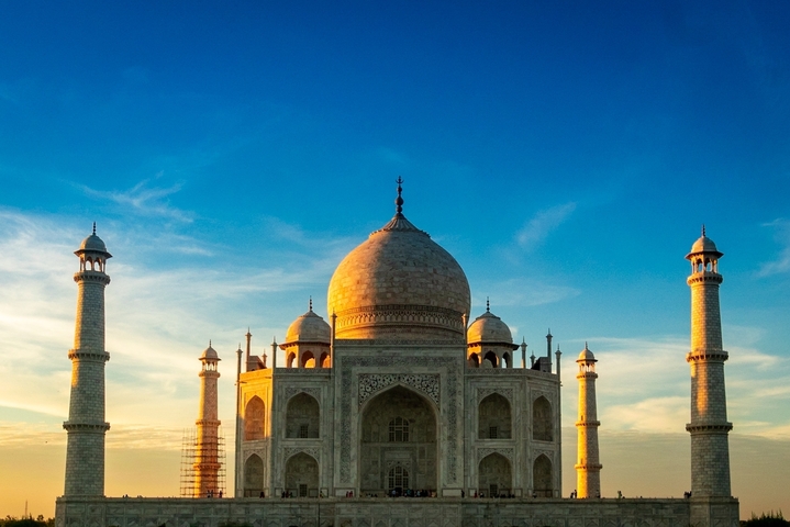 Iconic view of the Taj Mahal under a blue sky.