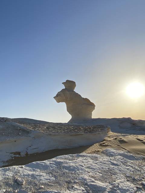 A rock formation resembling a mushroom shape in a desert.
