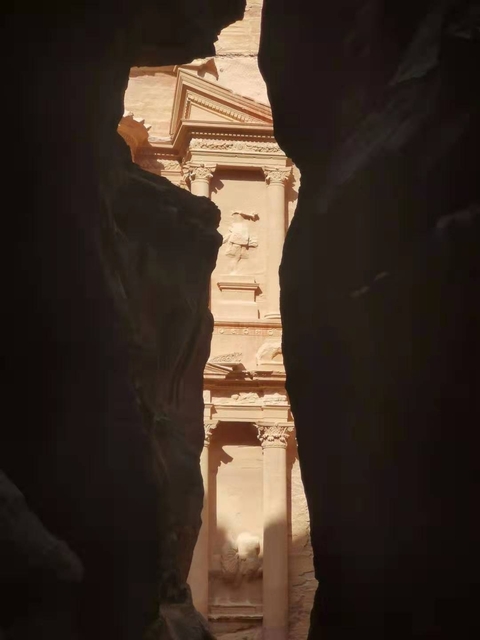 The Siq canyon with a glimpse of the Treasury in Petra.
