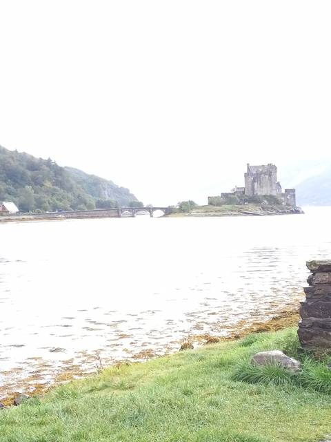 A scenic view of a castle across a lake.