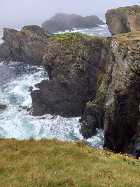 Rocky coast with waves crashing against cliffs.