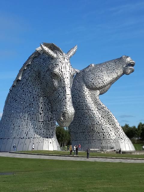 The Kelpies sculptures against a bright blue sky.
