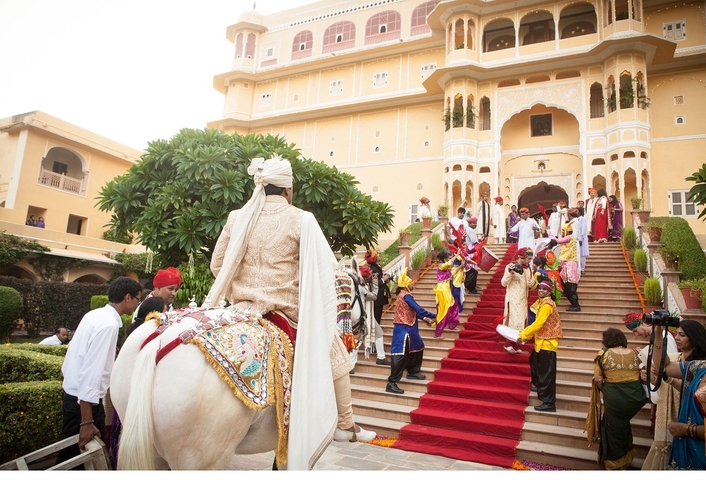 Traditional celebration with horseback riding at a grand building.