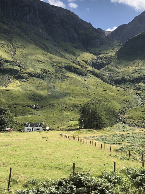 Scenic hillside landscape with a house and waterfall