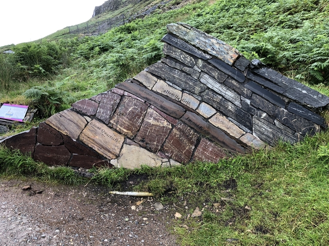 Rock strata display sign on a grassy slope