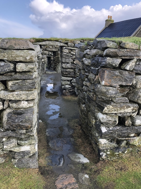 Stone walls or ruins with a narrow path.