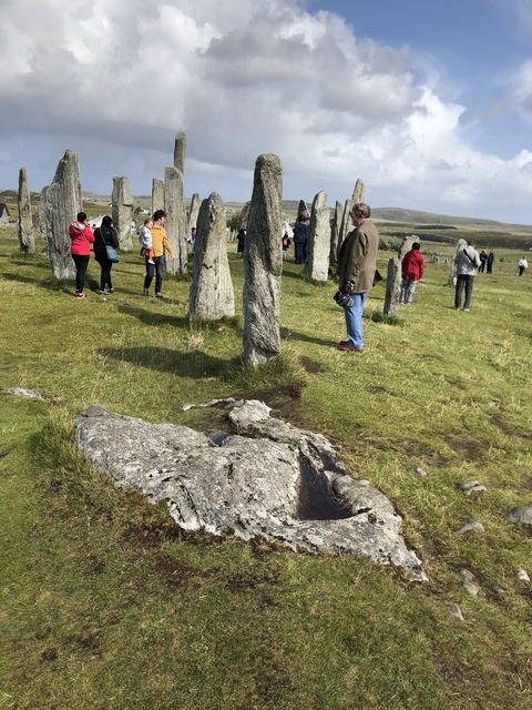 People exploring a stone circle site.