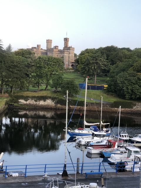 Small harbor with boats and a historical building in the background