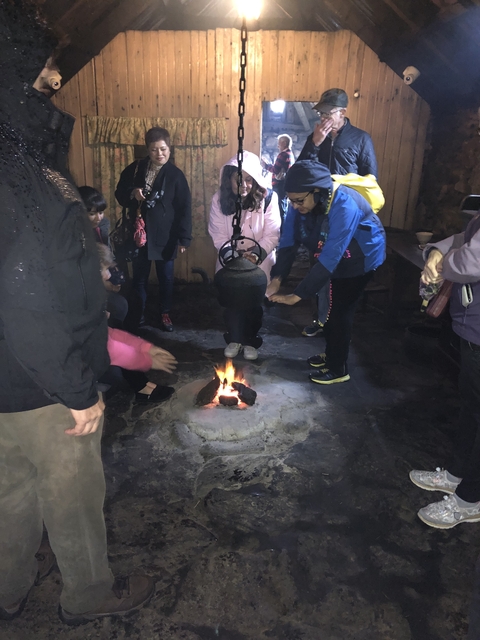 Group gathered around a small campfire in a historical setting