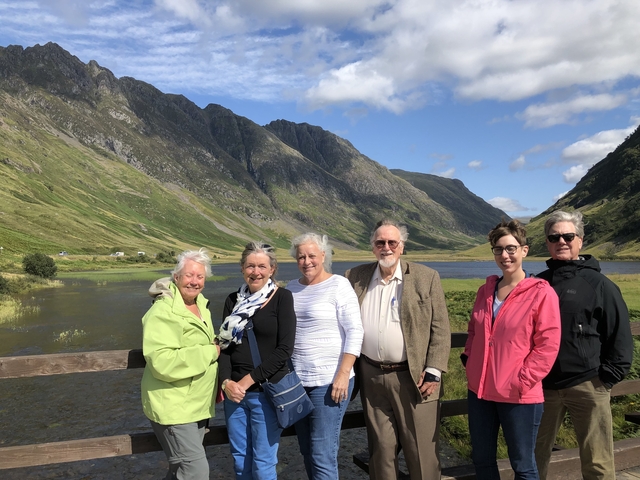 Group of tourists posing in front of scenic mountains