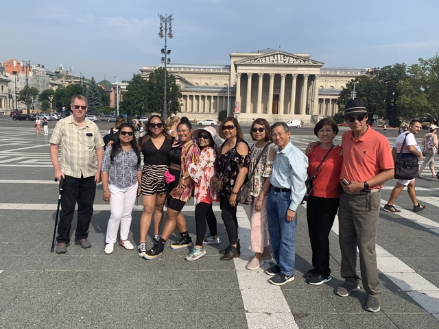 Group posing in front of a historic building
