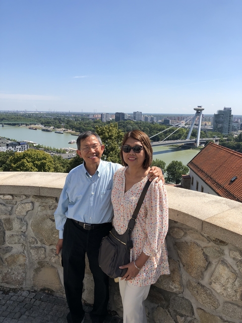 Couple posing with a bridge and city view