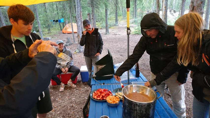 People preparing food at a campsite.