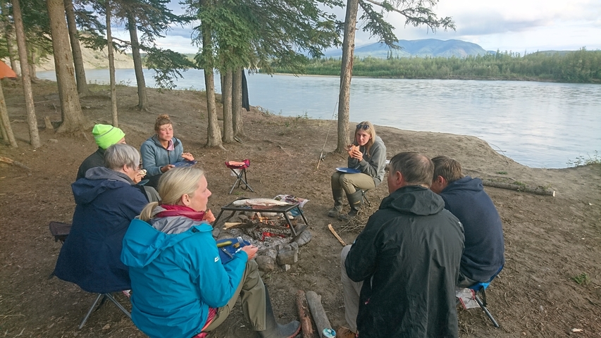 Group enjoying a meal by the river.