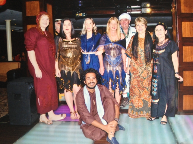 Group of people in themed attires posing indoors.