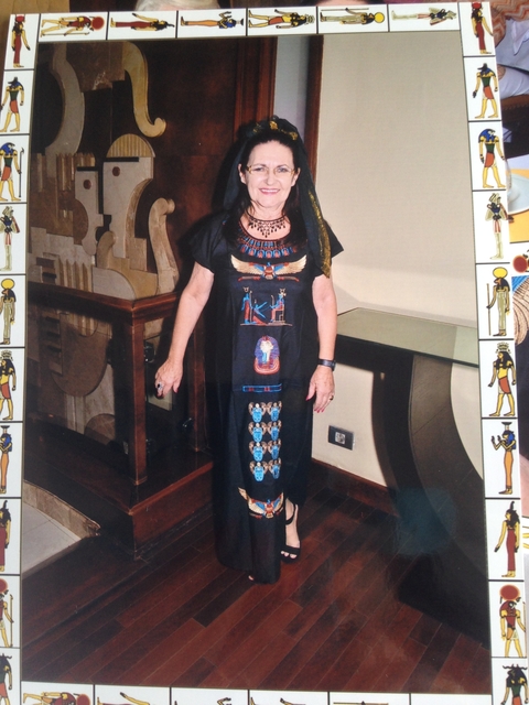 Person in Egyptian-themed attire standing indoors.