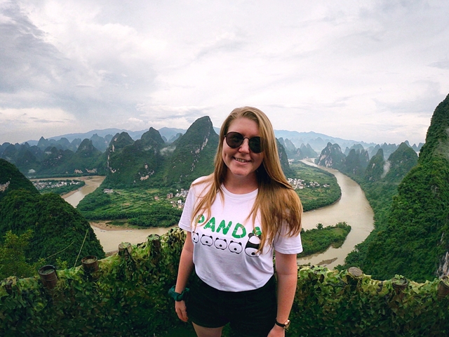 Woman posing with karst landscape in the background.