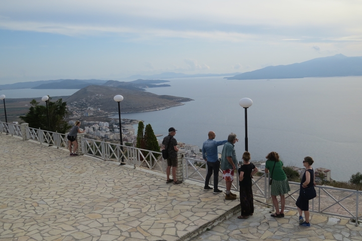 People looking at a coastal view from a terrace.