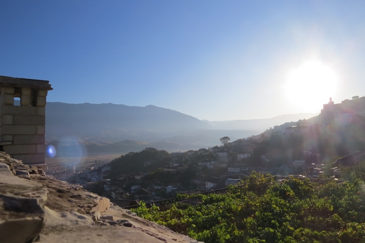 Sunset over a hilly landscape with a city.