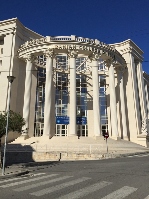 White building with tall columns and glass windows.