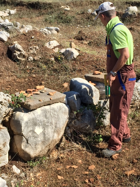 Person working with stones in an outdoor setting.