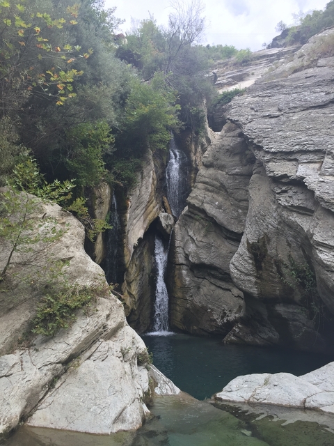 Waterfall flowing between rocky cliffs.
