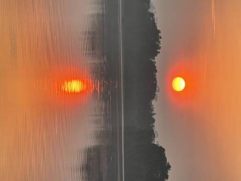 Sunset view over a river with reflections on the water.